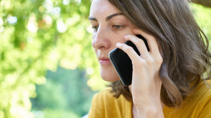 Woman looking anxious while holding a mobile phone