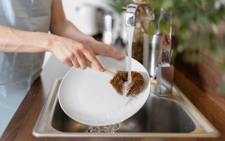 Person using water at kitchen sink