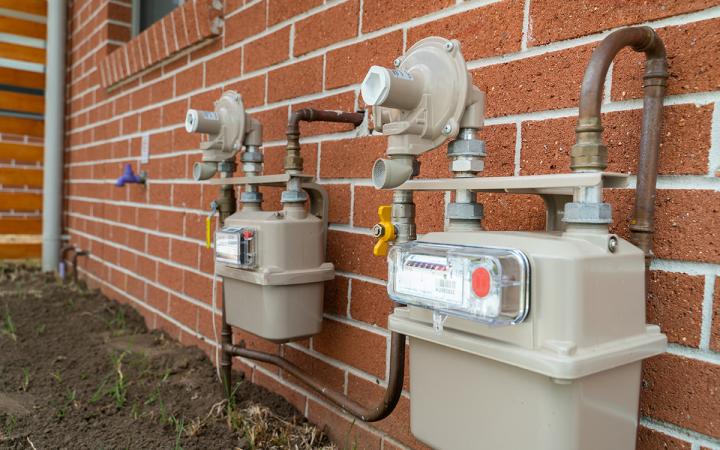 Image of two gas meters attached to a brick wall