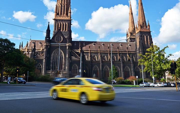 Taxi in Melbourne driving past St Patrick's Cathedral